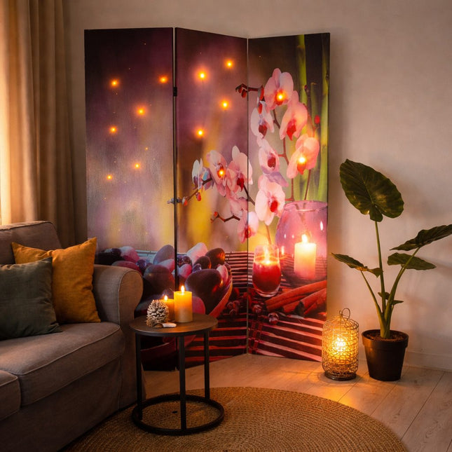 Wellness kamerscherm met LED-verlichting en orchideeënmotief, sfeervol geplaatst in woonkamer als decoratieve scheidingswand met warme spa-uitstraling.
