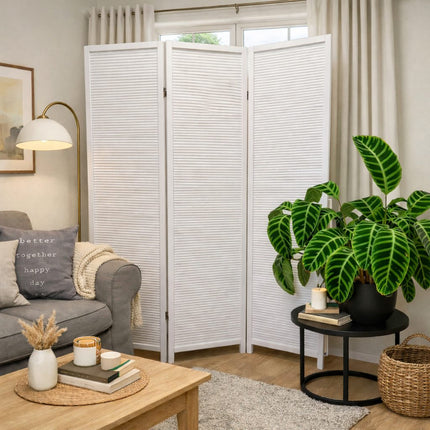 Wit houten kamerscherm met 3 panelen in sfeervolle woonkamer setting met raam en beige gordijnen op de achtergrond