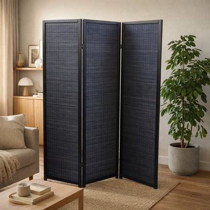 Sfeervolle woonkamer met zwart kamerscherm en grote kamerplant in neutrale pot