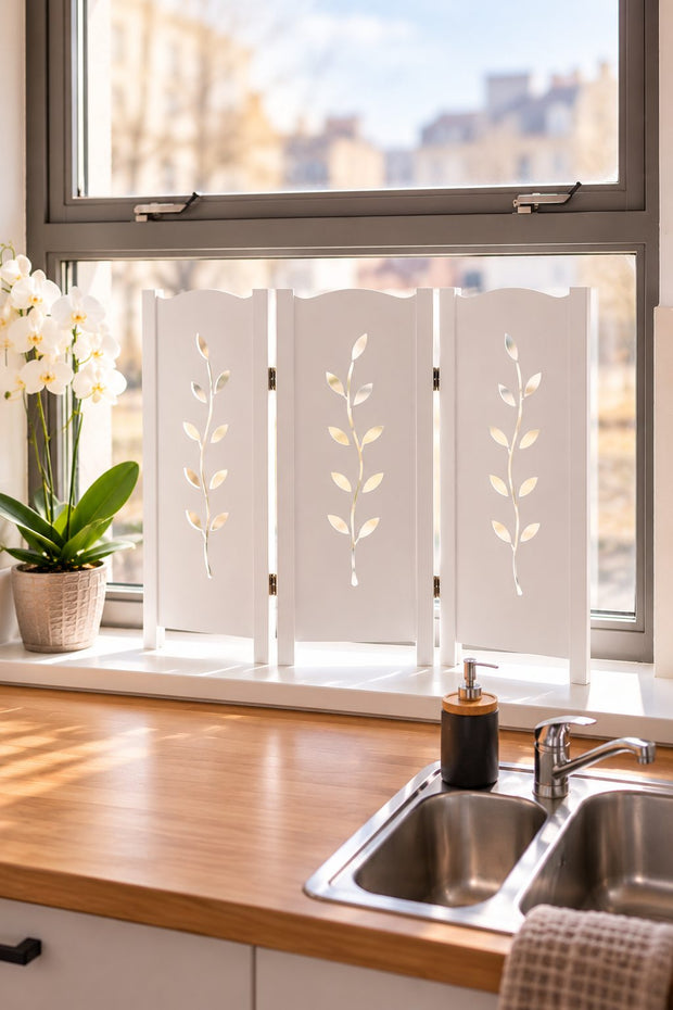 Wit raamscherm PureLeaf met 3 panelen en decoratieve bladuitsnedes op de vensterbank in een sfeervolle keuken met natuurlijke lichtinval.