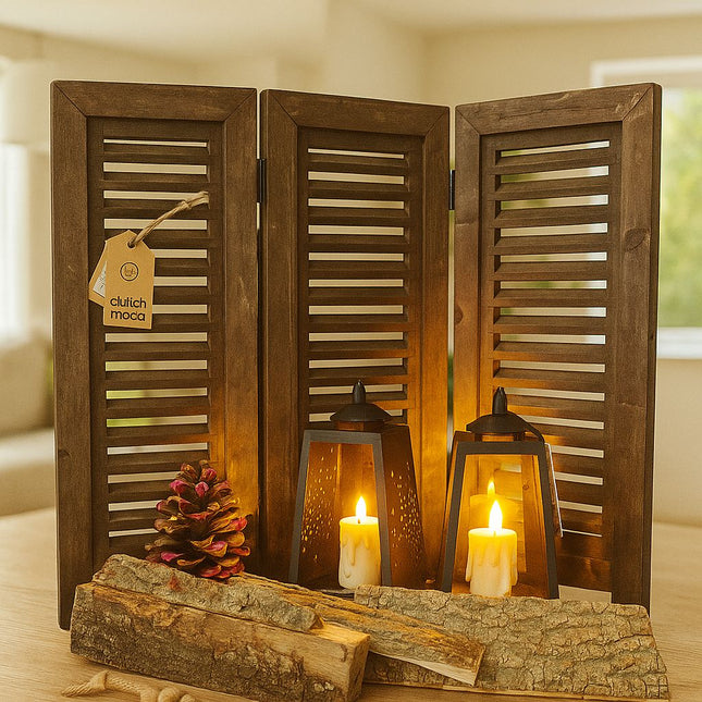 Klein vintage kamerscherm van verweerd hout met dennenappel, houtblokken en kaarsen op tafel