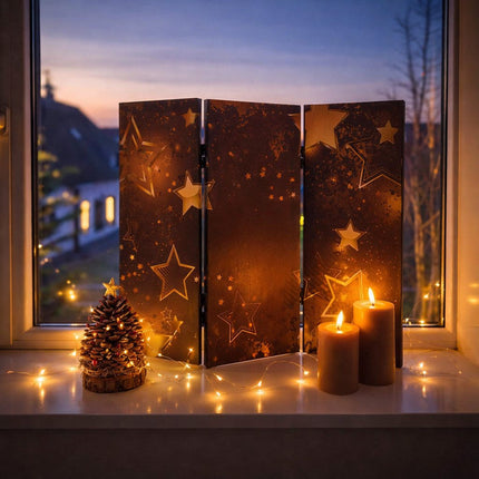 Sfeervolle decoratieve raamscherm met sterrenmotief op een witte vensterbank, gecombineerd met LED-kaarsen en een dennenappel decoratie, tegen een avondlucht bij het raam.