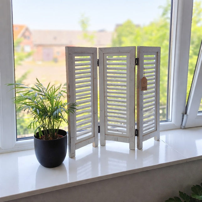 Klein wit houten raamscherm als raamdecoratie op vensterbank met plant